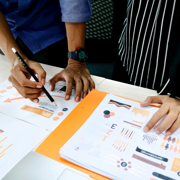 two individuals reviewing a series of charts and graphs