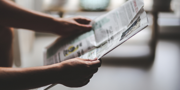 Hands holding a newspaper