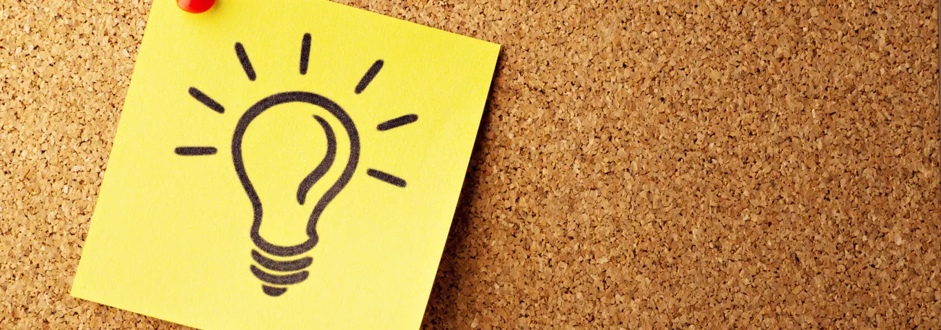 bulletin board with a drawing of a lightbulb pinned to it