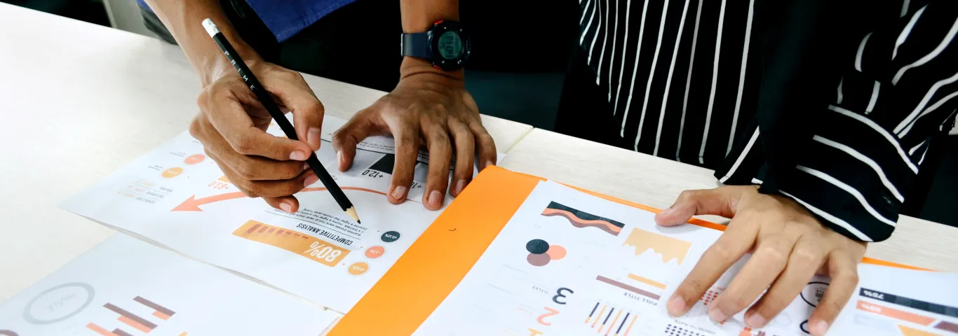 two individuals reviewing a series of charts and graphs