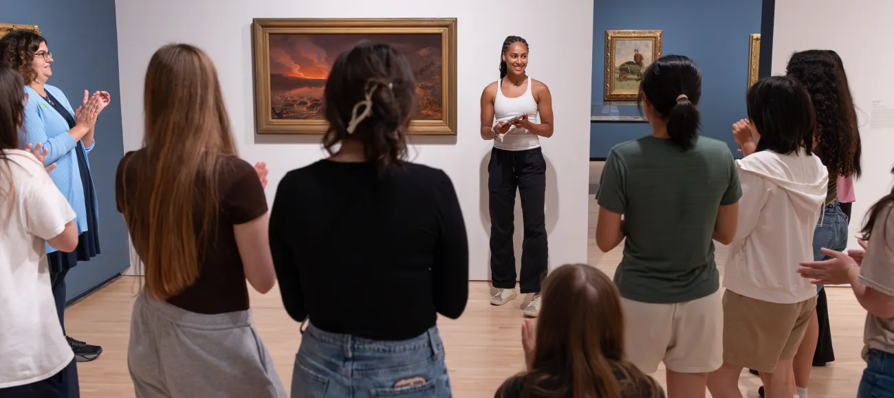 Students standing by art work