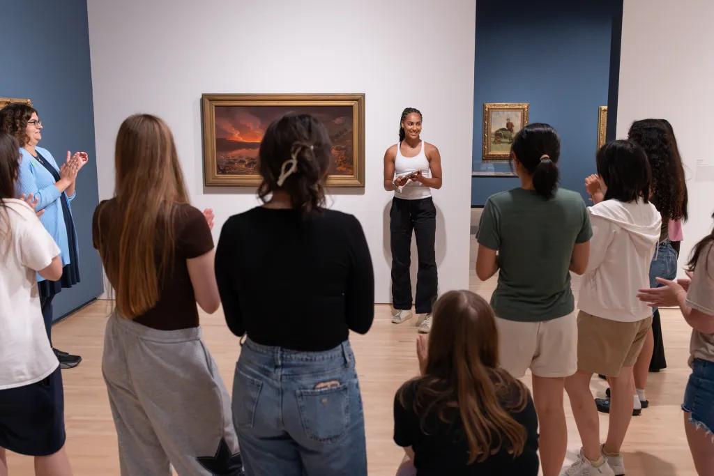 Students standing by art work