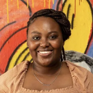 picture of woman in front of mural