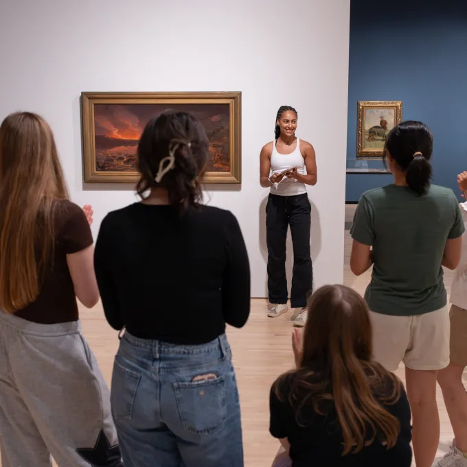 Students standing by art work